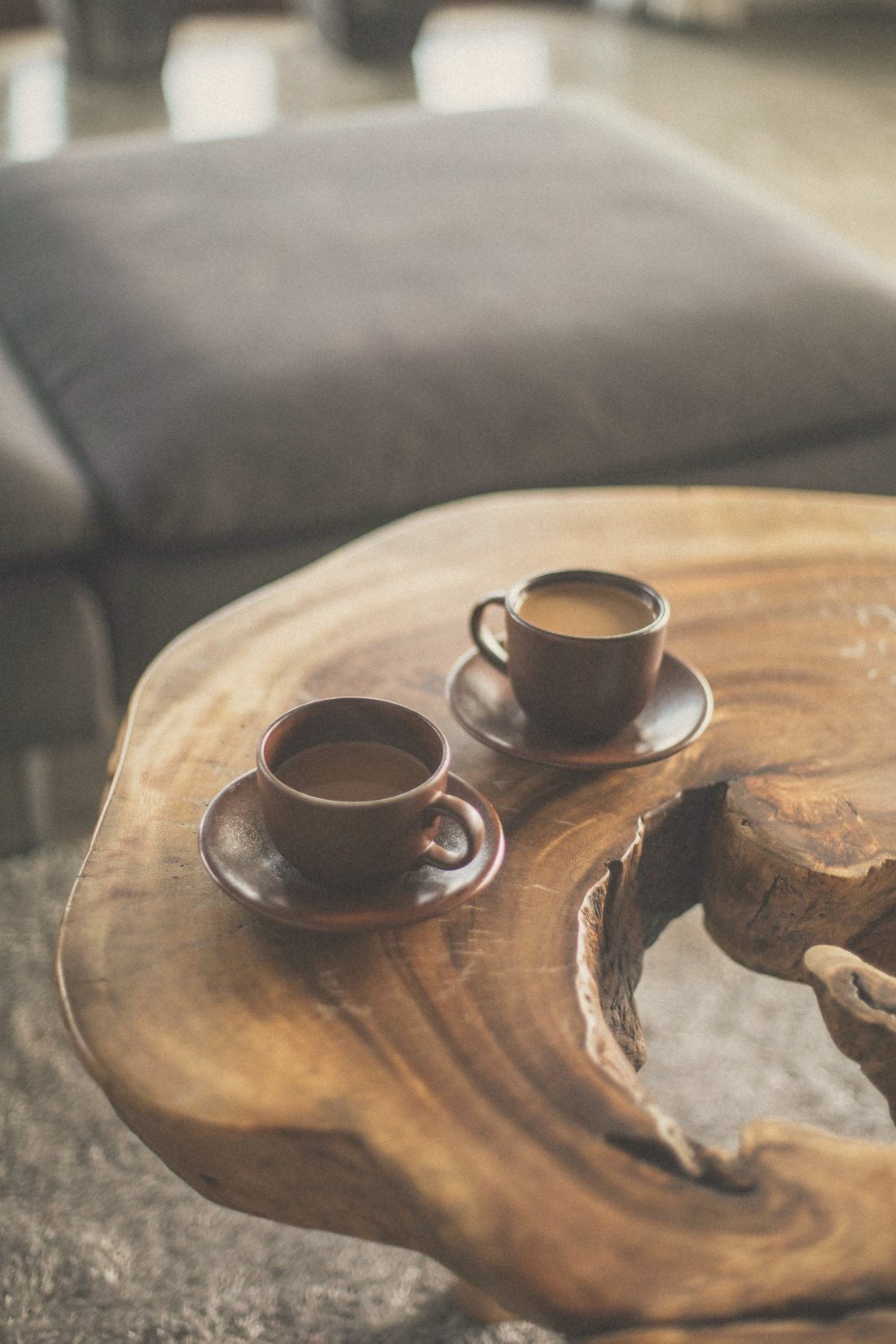 Two cups of coffee on a rustic wooden table, suggesting connection and conversation between partners